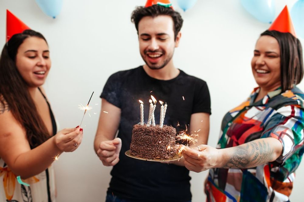 Friends celebrating a birthday with cake and sparklers